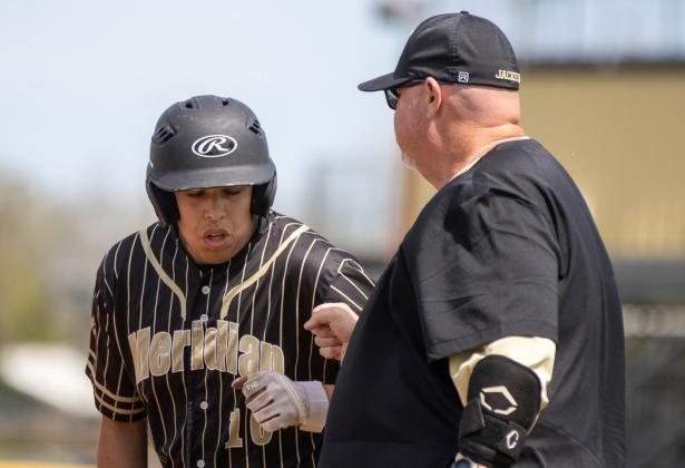 Meridian junior Jesus Martinez (10) congratulated by Jacket assistant coach Kevin Brister (right). Photo courtesy of Brett Voss’ The Sports Buzz