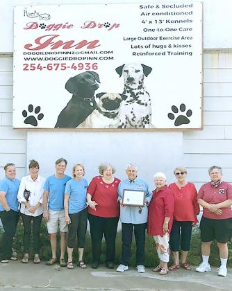Caption for picture of Helen Hubler and friends in front of the Doggie Drop Inn billboard on the side of Tha Washhouse (W 5th and Ave E). Courtesy Photo | The Clifton Record