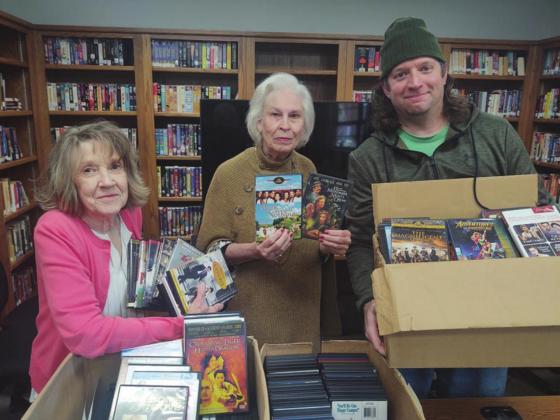From left, Clova Gibson, Kathleen Hale from the Valley Mills Public Library accepts a collection of donated DVDs from Nathan Diebenow on behalf of the Bosque Film Society. Photo Courtesy of Bryan Davis