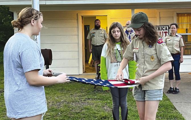 The first members of the all-girls Scouts BSA troop in Bosque County Cassidy Dunnam (from left), Randi Holder, and Samantha Grelle -- fold the American flag after their first meeting in Clifton in April 2023. Nathan Diebenow | Meridian Tribune